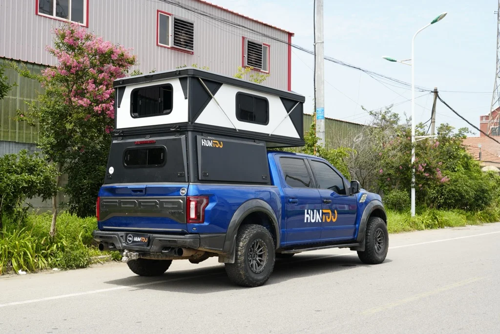 Aluminum pop-up pickup canopy camper shown raised on a pickup truck outdoors
